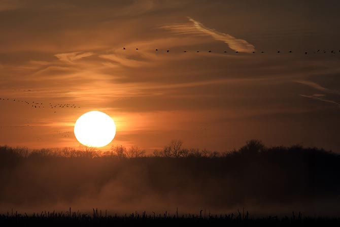President’s Message: Closing the Year with Purpose and Momentum; a dark orange sky with a sun setting.