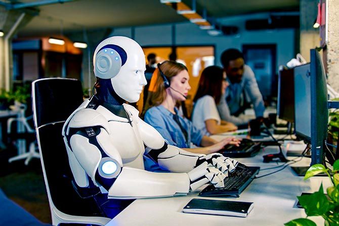 The Future of AI in Banking; A humanoid robot sits at a computer in a busy office, surrounded by people working. The scene conveys a futuristic and collaborative work environment.