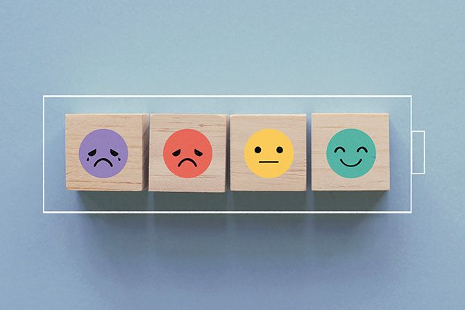 The Mental Toll of Money Stress; Wooden blocks showing various emotions