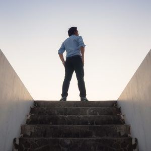Man standing at the top of stairs looking in the distance