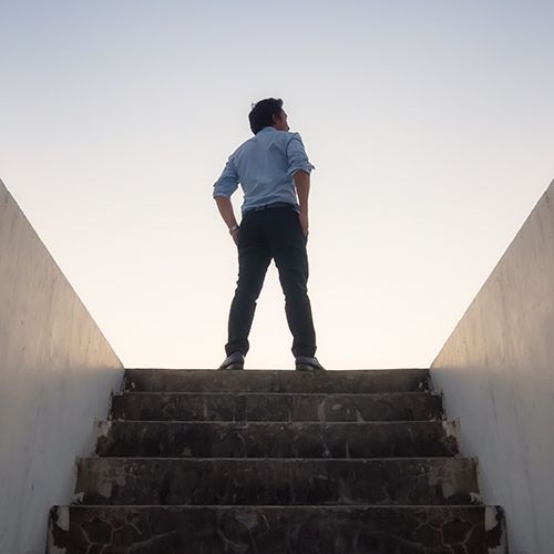 Man standing at the top of stairs looking in the distance